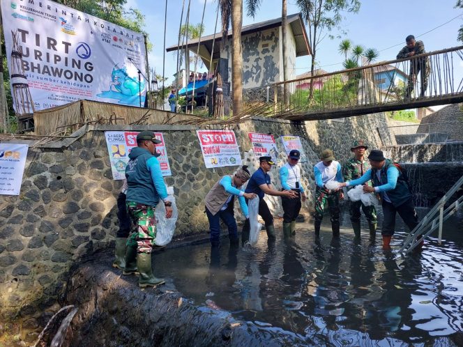 
 Pj. Wali Kota Batu Aries Agung Paewai bersama Lurah Temas Adi Santoso, saat menebar bibit ikan Tombro Punten di Sungai Wunut. (Eko)
