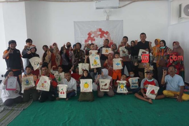 
 Anak-anak istimewa bersama para pendampingnya menunjukkan hasil melukis Totebag di ruang seni lantai 4 Gedung Malang Creative Center (MCC) di Kota Malang, Sabtu (8/4/2023). (Nedi Putra AW)
