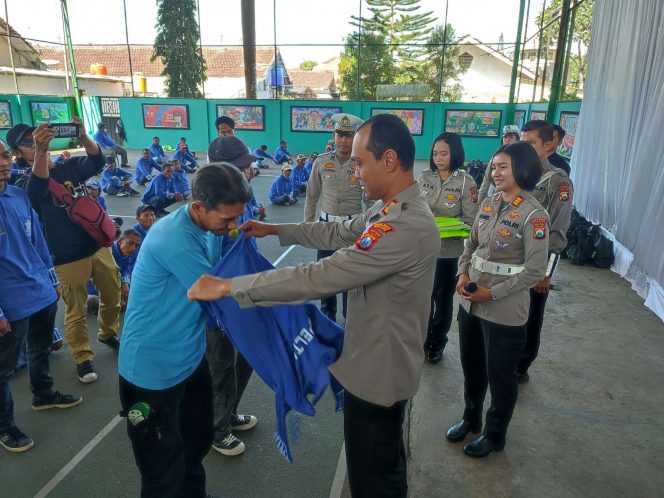 
 Kapolres Malang AKBP Putu Kholis Aryana secara simbolis memberikan baju kepada Supeltas. (bacamalang/Dhimas) 