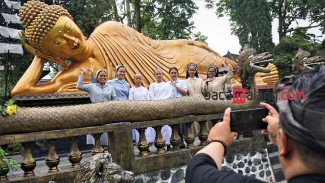 
 Rombongan dari Gereja Katolik Paroki Gembala Baik Kota Batu berfoto dengan dua Atthasilani di depan patung Buddha Tidur di Vihara Dhammadipa Arama, Desa Mojorejo, Kecamatan Junrejo, Kota Batu pada Minggu (4/6/2023). (Nedi Putra AW)