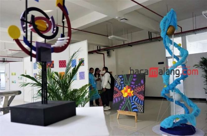 
 Tiga orang pengunjung mengamati sejumlah karya para mahasiswa DKV Universitas Ma Chung dalam Tongseng & PAS 2023 di Gedung MCC, Minggu (18/6/2023). (Nedi Putra AW)
