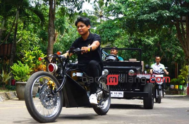 
 Kepala Program Keahlian Otomotif SMKN 10 Kota Malang Aditya Sukma Wijaya SPd Gr mengendarai motor listrik Chopper Vocsten diikuti mobil Jeep K10 dan salah satu motor listrik hasil rakitan timnya di sekolah setempat, Rabu (13/12/2023). (Nedi Putra AW)