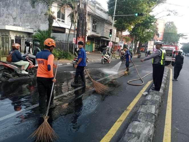 
 Petugas UPT PMK Kota Malang saat membersihkan tumpahan solar di perempatan Jalan Panglima Sudirman Kota Malang, Minggu (23/6/2024) (ist)
