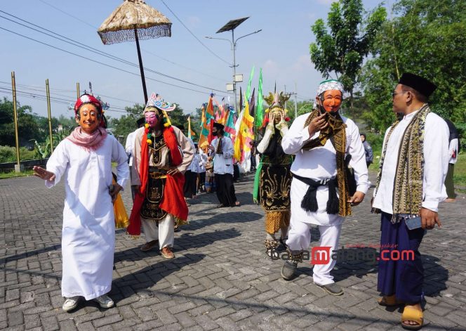 
 Wayang Topeng Menak menjadi bagian dalam rombongan Kirab Gunungan Takir sebagai bagian dari tradisi Mbabar Bubur Suro menyambut 1 Muharram 1446H oleh Pokdarwis Kampung Gribig Religi Kota Malang, Sabtu (6/7/2024). (Nedi Putra AW)
