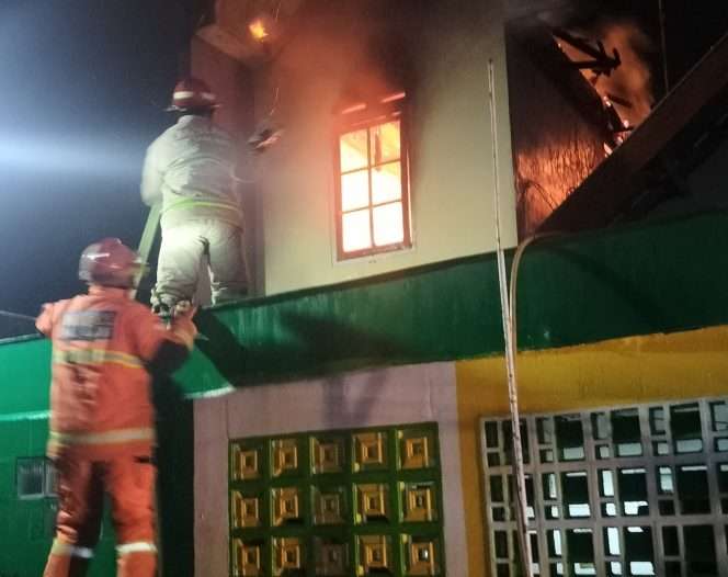 
 Petugas PMK Kota Malang berupaya memadamkan api di rumah Sarwono di Jl. Lesti. (Ist)
