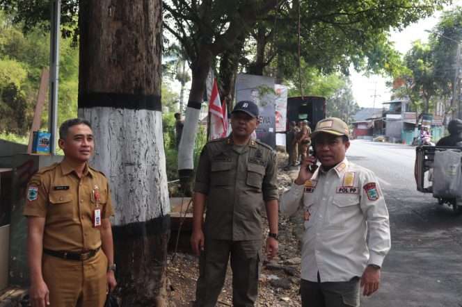 
 Kasatpol PP Kota Batu, Abdul Rais saat tengah turun langsung ke lapangan untuk menertibkan banner, yang tidak sesuai dengan aturan. (Yan)
