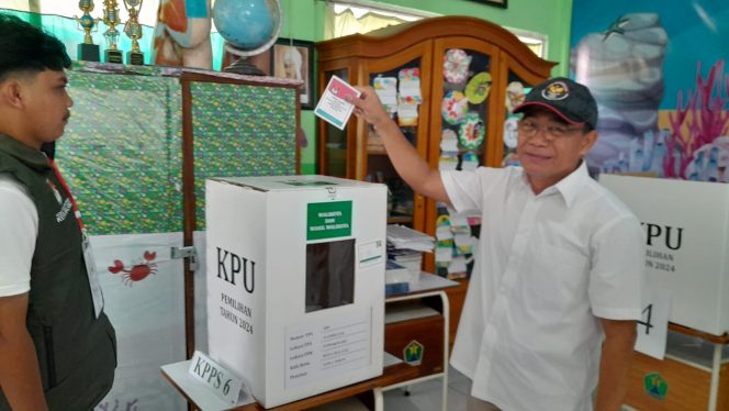 
 Muhadjir Effendi memasukkan surat suara usai mencoblos kertas suara di TPS 020 (Rohim Alfarizi)