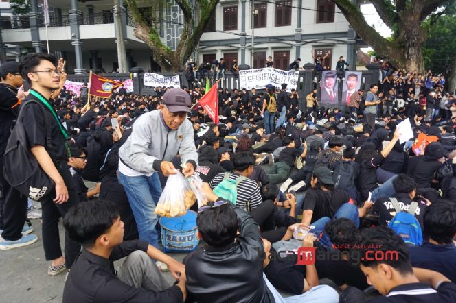 
 Massa menyempatkan membeli dagangan para penjual di sela demo, Selasa (18/2/2025). (Nedi Putra AW)