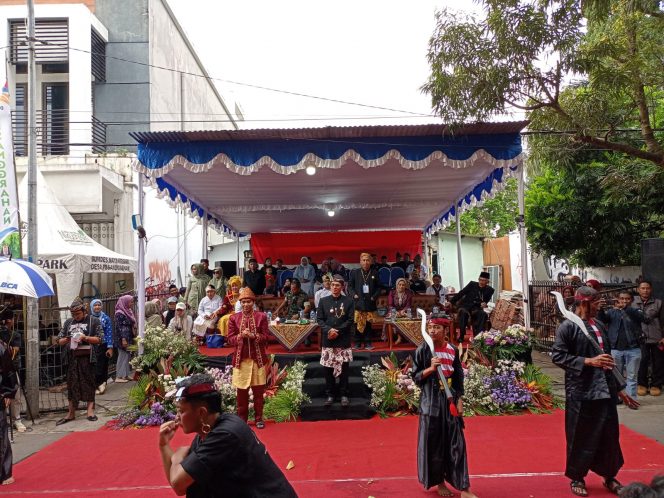 
 Kades Pesanggrahan, Imam Wahyudi dan Camat Batu, Sasongko Fitra Adhitama, saat berdiri di depan panggung kehormatan menyaksikan Karnaval Budaya Pesanggrahan Art and Culture Carnival. (Yan)