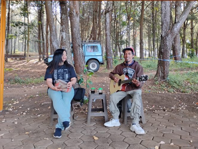 
 Pengamen penyandang disabilitas, Eko Pramono saat tengah mengamen di Payung Pinus, Jalibar bersama salah seorang wisatawan yang request lagu. (Yan)