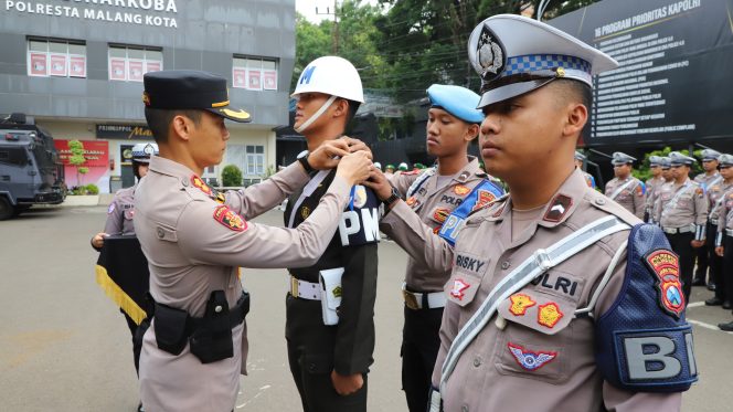 
 Inspektur Upacara AKBP Oskar menyematkan pita kepada anggota PM yang terlibat dalam Operasi Zebra Semeru 2025. (ist)