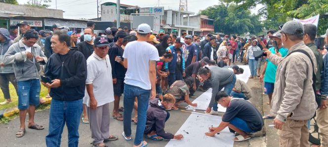 
 Dalam aksinya, massa membawa poster dan membubuhkan tanda tangan di atas kain putih sebagai simbol aspirasi bersama. (ist)