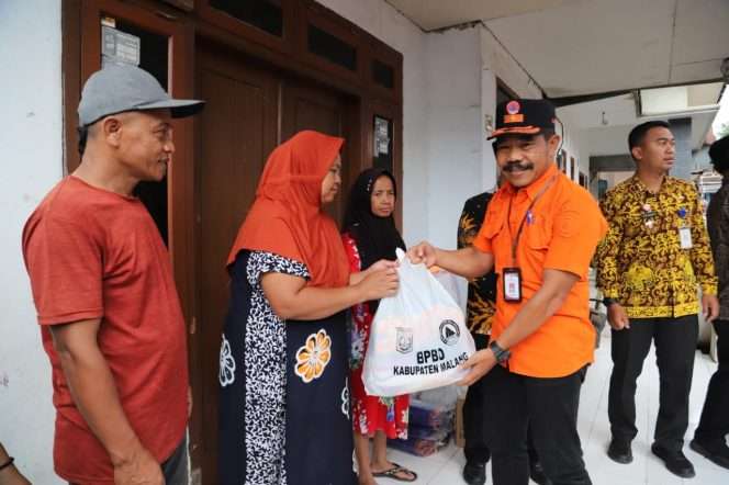 
 Kalaksa BPBD Kabupaten Malang, Purwoto, memberikan bantuan untuk terdampak bencana di Tajinan. (Dok Pemkab Malang)