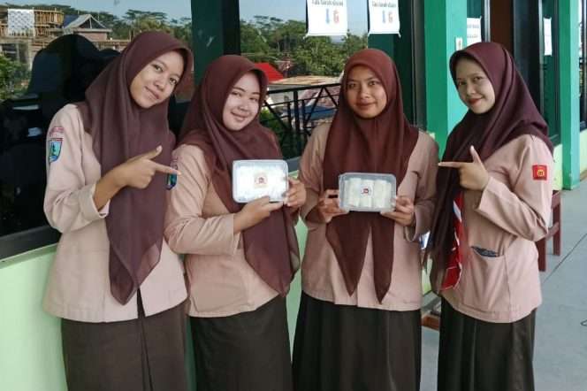 
 Dinda, Citra, Maulidatul, dan Windi, siswi kelas 3 Madrasah Aliyah (MA) An-Nur Sawahan, Kecamatan Turen, Kabupaten Malang, membawa produk Lumpia kreasinya, yang penjualannya meningkat saat Ramadan. (Dinda for Baca Malang)