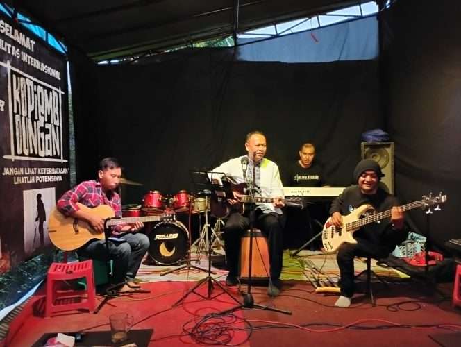 
 Camat Bumiaji, Thomas Maido saat bermain musik bersama musisi penyandang disabilitas di Kopi Embongan. (Yan)