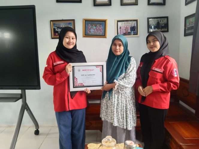 
 Perwakilan SMP PGRI As-Sarqowi simbolis menyerahkan piagam penghargaan kepada perwakilan GMNI Fakultas Tarbiyah Universitas Al-Qolam sebagai bentuk apresiasi atas pelaksanaan kegiatan sosialisasi bullying. (GMNI for Baca Malang)