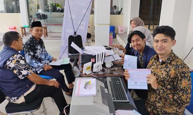 
 Kades Torongrejo, Takim, S.Pd., M.Pd, saat tengah membayar PBB di kantor Desa Torongrejo pelayanan program Mbatu SAE dari Bapenda Kota Batu. (Yan)