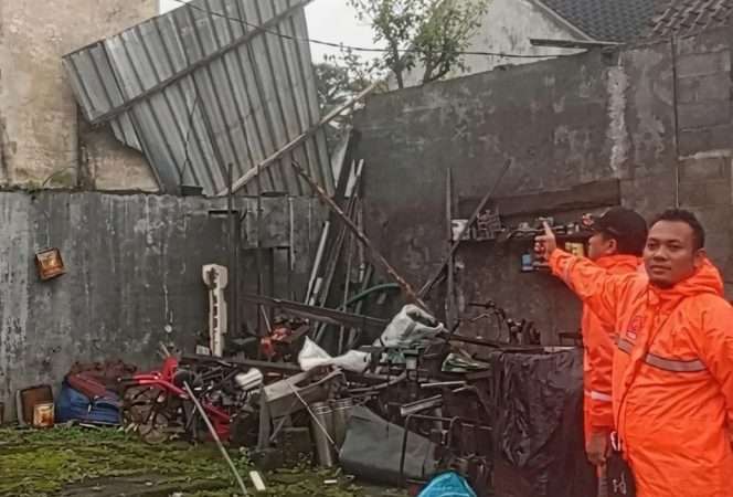 
 Personel BPBD Kabupaten Malang saat berada di lokasi melakukan asesmen, evakuasi pohon tumbang, dan menyalurkan bantuan darurat, dalam kejadian angin puting beliung di Jabung.(BPBD for Baca Malang)