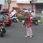 Sukarni mengenakan kebaya saat bertugas di pertigaan Jalan Semanggi Timur dan Jalan Soekarno Hatta, Kota Malang, Selasa (21/4/2026). (Nedi Putra AW)