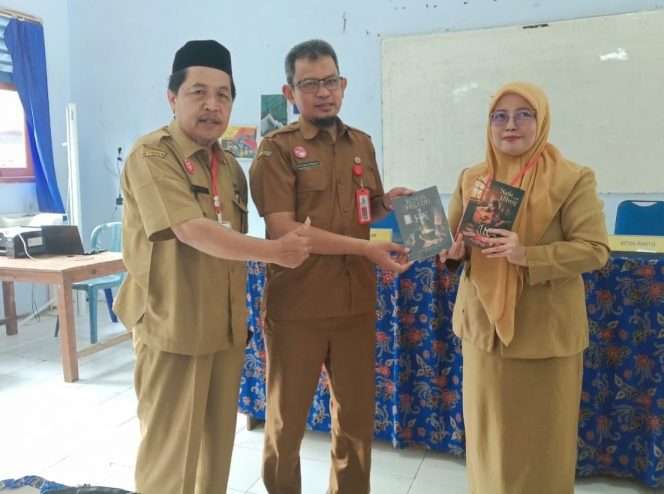 
 Guru pembina sekaligus editor, Riyami, simbolis memperlihatkan hasil karya orisinil siswa lima judul buku fisik. (Humas Dispendik Kabupaten Malang)
