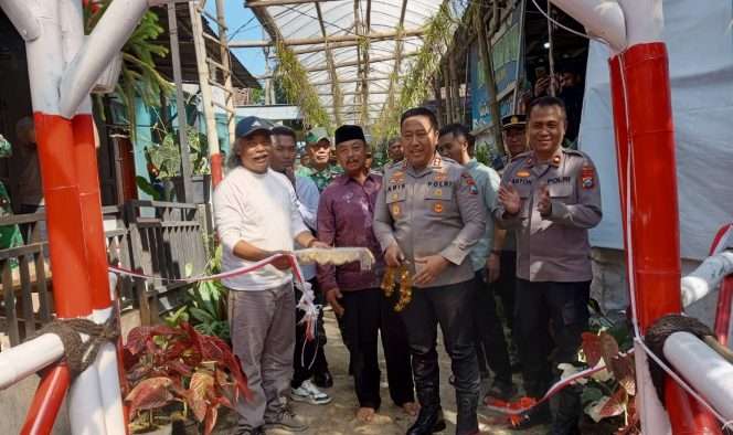
 Kapolres Batu, AKBP Dr. Aris Purwanto, S.H., S.I.K., M.H didampingi Kades Tulungrejo, Suliono saat tengah meresmikan Jembatan Merah Putih Presisi. (Yan)