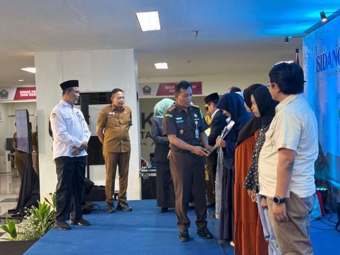 
 Kepala Kejaksaan Negeri (Kajari) Kota Malang, Tri Joko, saat menyerahkan dokumen pengesahan perwalian anak. (ist)