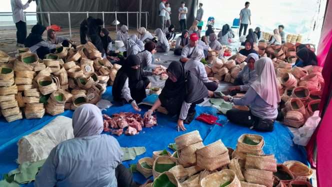 
 Petugas pembagian daging hewan kurban sedang mengemas paket daging kurban menggunakan besek. (ist)