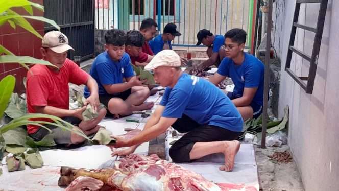 
 Panitia Kurban Masjid Babul Hidayah Tanjung membungkus daging kurban menggunakan daun jati sebagai pengganti plastik. (Rohim Alfarizi)