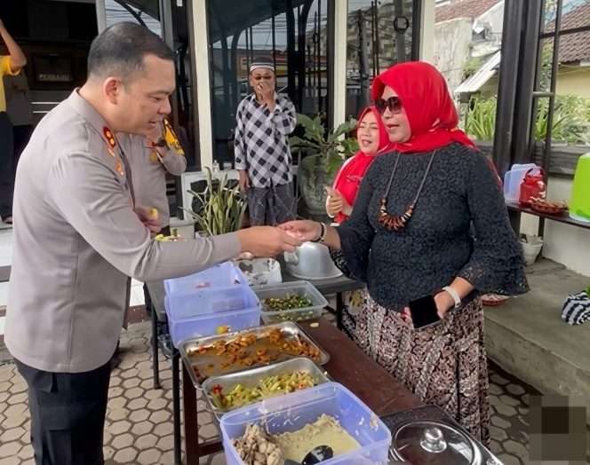 
 Kapolres Malang AKBP Muhammad Taat Resdianto, S.H., S.I.K., M.T.C.P, memberikan sumbangan uang, dalam kegiatan rutin Jumat Berkah yang digelar Ibu-Ibu Komunitas Wong nDeso di halaman Polsek Dampit, Jumat (5/6/2026). (IG Polsek Dampit)