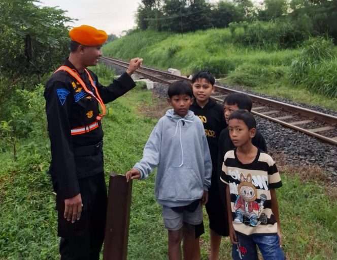 
 Petugas keamanan KAI Daop 8 memberikan peringatan kepada sejumlah anak yang sedang bermain di jalur rel kereta api. (ist)