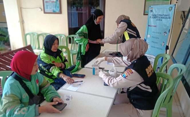 
 Petugas Dokkes Polresta Malang Kota melakukan pemeriksaan kesehatan terhadap salah seorang pengemudi ojek online (ojol) perempuan. (ist)