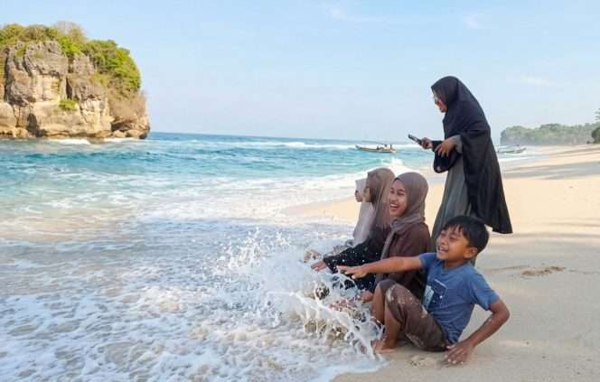 
 Sanak saudara, dari keluarga besar Anang Fauzi, warga Turen, tampak bermain ombak, mengisi liburan mengunjungi Pantai Ngudel di Desa Sindurejo, Kecamatan Gedangan. (Anang for bacamalang)