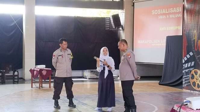 
 Wakapolsek Lowokwaru AKP Bagus Setioko Darmawan didampingi Bhabinkamtibmas Kelurahan Sumbersari, Aipda Endar, memberikan edukasi kepada peserta Masa Pengenalan Lingkungan Sekolah (MPLS) di SMAN 8 Malang. (ist)