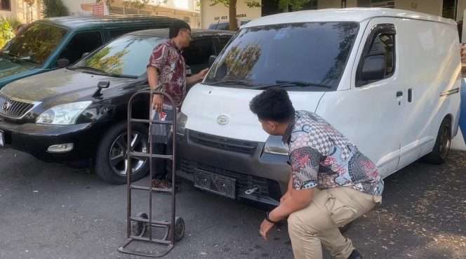 
 Anggota Satreskrim Polres Batu, saat tengah mengamankan mobil Daihatsu Grandmax yang dipakai pelaku untuk membobol gudang Indomarco Adi Pratama. (Yan)