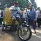 Direktur Jenderal Bina Administrasi Kewilayahan Kemendagri, Safrizal ZA mencoba e-bike gerobak sampah yang diserahkan dari CSR perusahaan untuk mendukung Pencanangan Gerakan Indonesia ASRI oleh Satpol PP seluruh Indonesia di Alun-alun Merdeka Kota Malang, Jumat (10/7/2026). (Nedi Putra AW)