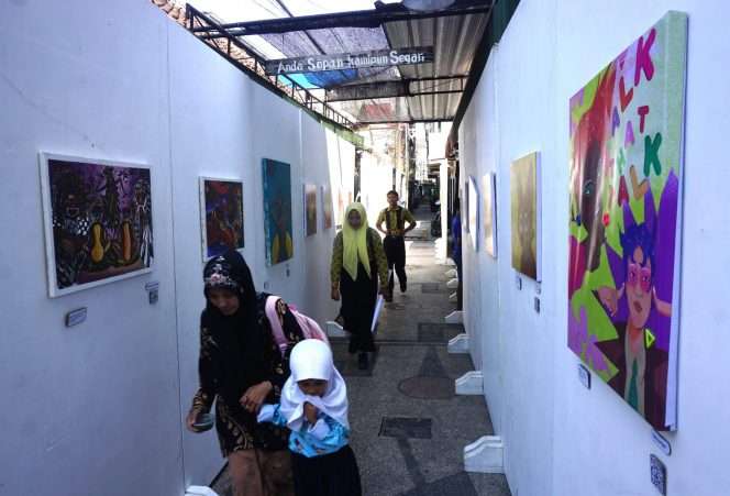
 Sejumlah warga melintas salah satu ruas gang yang dimanfaatkan untuk galeri pameran 