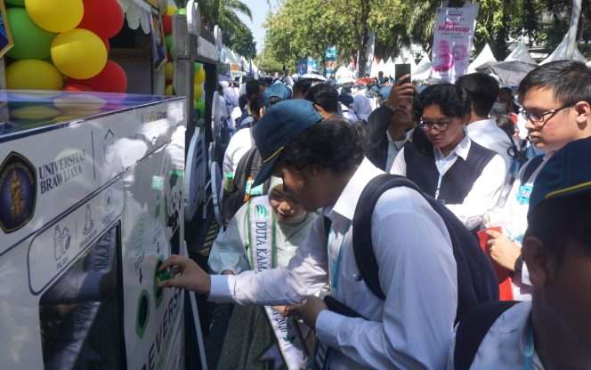
 Para mahasiswa baru mencoba Reverse Vending Machine (RVM), mesin pengumpul botol plastik yang dilengkapi teknologi Internet of Things (IoT) di Booth UBGC depan FILKOM UB, dalam rangkaian Open House dan puncak penutupan Raja Brawijaya, Sabtu (29/8/2026). (Nedi Putra AW)
