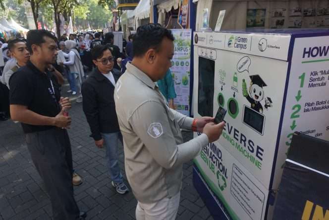 
 Kepala Bidang Infrastruktur Hijau, Manajemen Limbah, dan Sirkular Ekonomi UPT UBGC Angki Wahyu Putranto, STP, MP, PhD dan Co-Founder iLitterless Indonesia, Mayedha Adifirsta, S.Sos., M.Sos. mendampingi seorang pengunjung mencoba  Reverse Vending Machine (RVM), mesin pengumpul botol plastik yang dilengkapi teknologi Internet of Things (IoT) di Booth UBGC depan FILKOM UB, dalam rangkaian Open House dan puncak penutupan Raja Brawijaya, Sabtu (29/8/2026). (Nedi Putra AW)