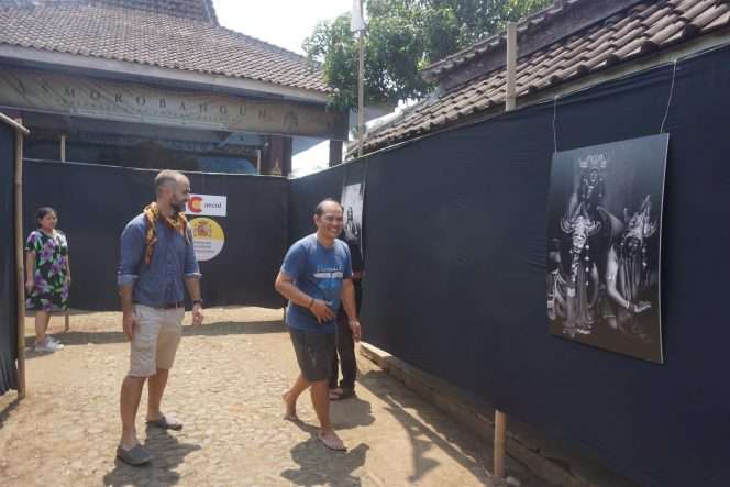 
 Diego Zapatero, fotografer sekaligus antropolog visual asal Zaragoza, Spanyol, mendampingi pengasuh Padepokan Asmorobangun, Tri Handoyo meninjau pameran foto di Sanggar Asmorobangun, Pakisaji, Kabupaten Malang, Minggu (23/8/2026). (Nedi Putra AW)
