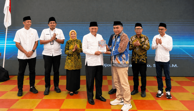 
 Ketua Forum Cangkrukan Pancasila, Dr. Djoni Sudjatmoko, menyerahkan buku tentang Ekonomi Pancasila kepada GS Kikin. (ist)