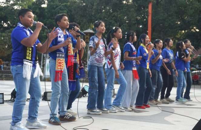 
 Miben Voice dengan atribut khas Arema saat tampil dalam Road to Festival Mbois 11 Malang Menyala di Alun-Alun Kota Malang, Selasa (11/8/2026). (Nedi Putra AW)