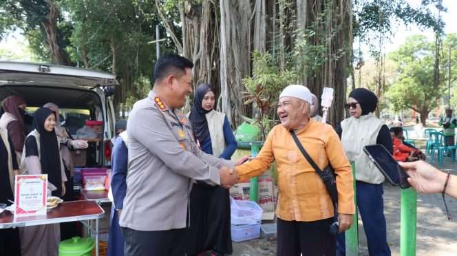 
 Kapolresta Malang Kota Kombes Pol Danang berjabat tangan dengan warga saat kegiatan makan bersama dan pemeriksaan kesehatan gratis. (ist)