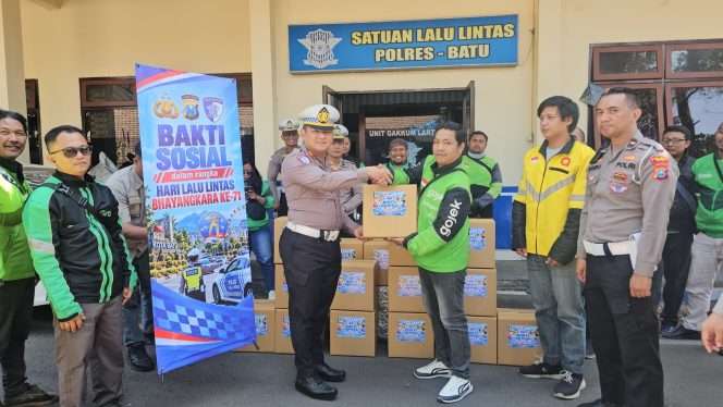 
 Kasatlantas Polres Batu, AKP Matheus Jaka Iswantara, S.H., M.H saat tengah memberikan bingkisan kepada ojol Kota Batu. (Yan)