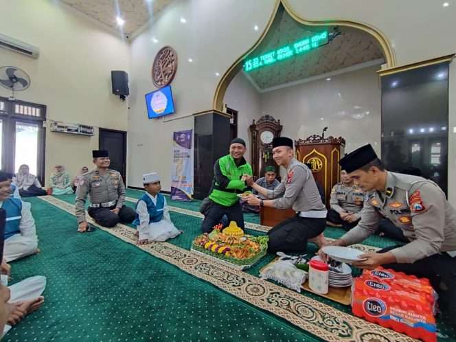 
 Kasatlantas Polres Malang secara simbolis memberikan potongan tumpeng kepada perwakilan pengemudi ojol dalam rangka tasyakuran dan doa bersama HUT Lantas. (ist)