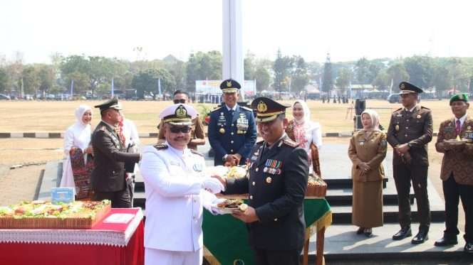 
 Kapolresta Malang Kota Kombes Pol. Danang menerima potongan tumpeng dari Danlanal dalam peringatan HUT ke-81 TNI. (ist)