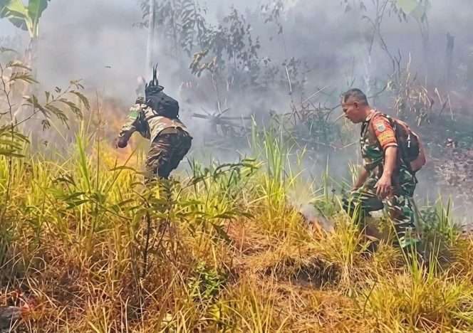 
 Personel kepolisian dan tentara melakukan pemadaman api. (IG Polsek Singosari)