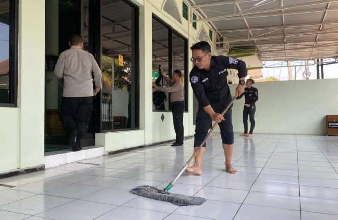 
 Kasi Humas Polresta Malang Kota, Ipda Lukman, bersama anggota Humas dan personel Polresta Malang Kota saat membersihkan Masjid Darussholihin. (ist)