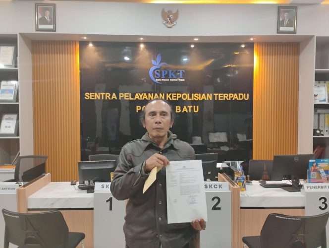 
 Zulkifli, jurnalis warga Kelurahan Sisir, Kecamatan Kota Batu, saat menunjukkan Surat tanda Terima Laporan di SPKT Polres Batu. (Yan)