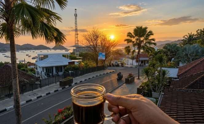 
 Di sela menanti kepulangan ke Malang, Yoeni menikmati secangkir kopi hitam sambil melepas penat dan mengenang perjalanan misi kemanusiaan di NTT, ditemani senja Labuan Bajo yang menawan. (Yoeni for BacaMalang)