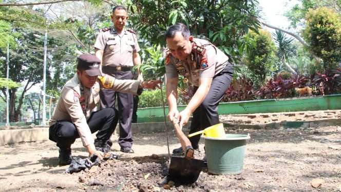 
 Wakapolresta Malang Kota, AKBP Alex, didampingi Kapolsek Lowokwaru, Kompol Nanang, saat melakukan penanaman pohon mangga. (ist)
